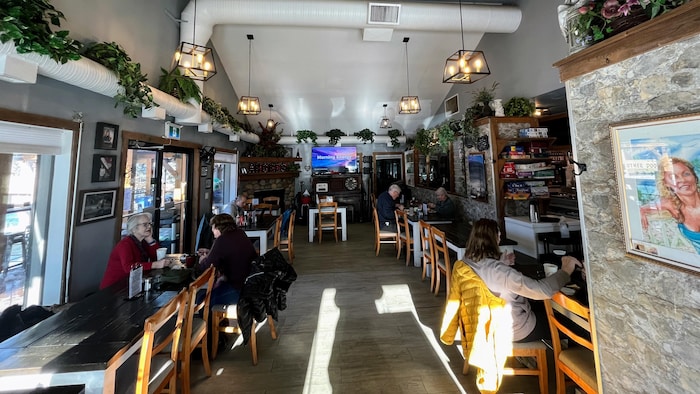 Une vue d'ensemble de la salle à manger de l'Angel's Café, où plusieurs clients sont attablés dans une ambiance chaleureuse.