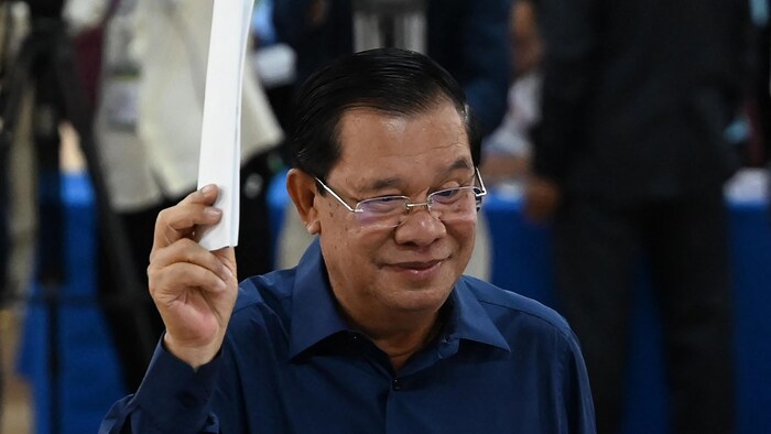 Hun Sen tient son bulletin de vote dans sa main droite.