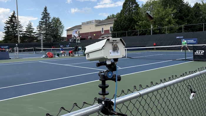 Une caméra près d'un terrain de tennis.