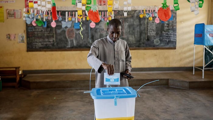 Un électeur dépose son bulletin dans une urne dans un bureau de vote.