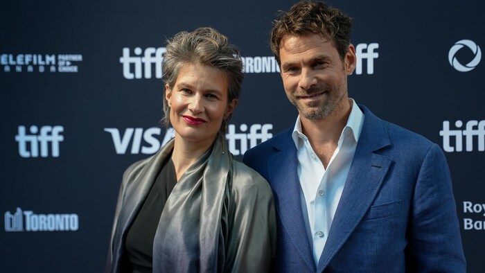 Camille and Clément Ducol pose for a photo on a red carpet.