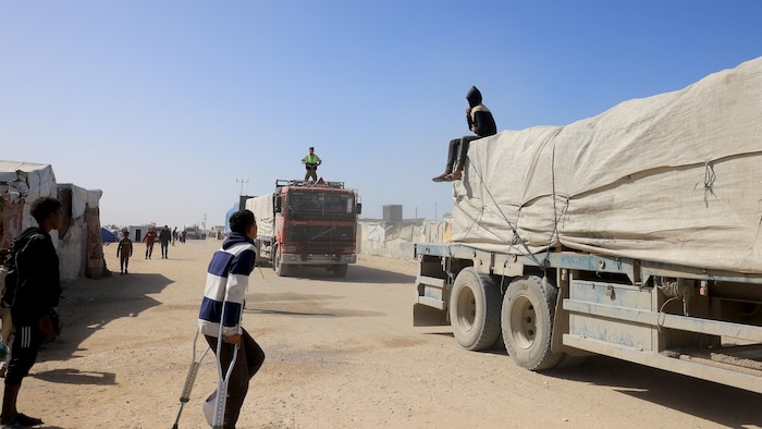 Des Palestiniens observent l'arrivée de camions transportant de l'aide humanitaire à Khan Younès, dans le sud de la bande de Gaza, le 1er février 2026.