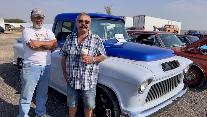 Jean-Marc Lacasse et Robert Denis debout devant une voiture ancienne.