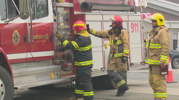 Des pompiers à côté de leur camion.