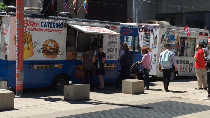 Des camions de cuisine de rue sur un trottoir.