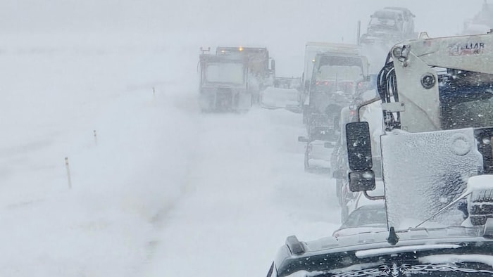 Des camions sur une route enneigée.
