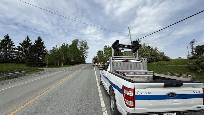 Une camionnette du ministère des Transports stationnée sur le bord d'une route.