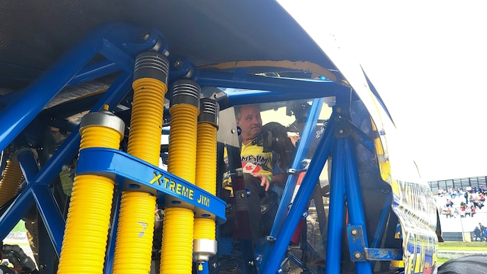 Un homme dans in camion monstre.