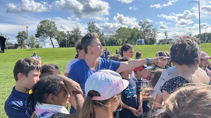 Une monitrice de camp de jour et des enfants.