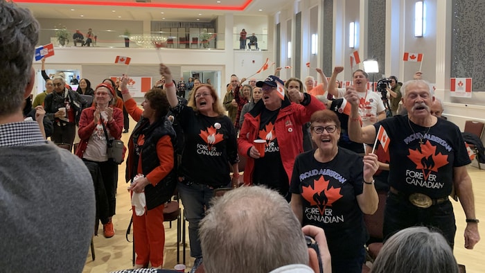 Les gens réjouissent au rassemblement du mouvement Canadiens pour toujours après les premiers résultats du référendum en Alberta, à Edmonton, le 19 octobre 2026.