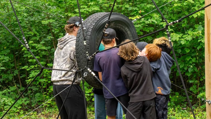 Des enfants jouent avec un pneu. 