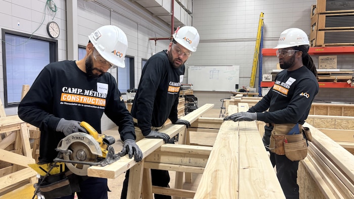 Trois personnes travaillent le bois.