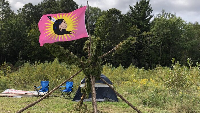 Image d'un drapeau traditionnel et d'une tente devant le Domaine des collines.