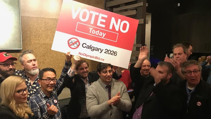 Vue sur un groupe de personne qui brandisse une affiche sur laquelle il est écrit: vote non aujourd'hui.