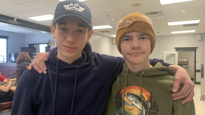 Les deux adolescents posent bras dessus, bras dessous.