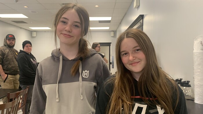 Les deux adolescentes posent ensemble dans un local.