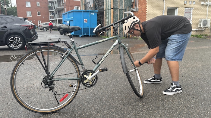 Zyad gonfle un des pneus de son vélo.