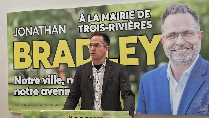 Jonathan Bradley devant une pancarte à son effigie.