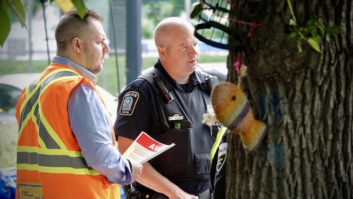Un policier et un employé du ministère des Transports dans le campement.