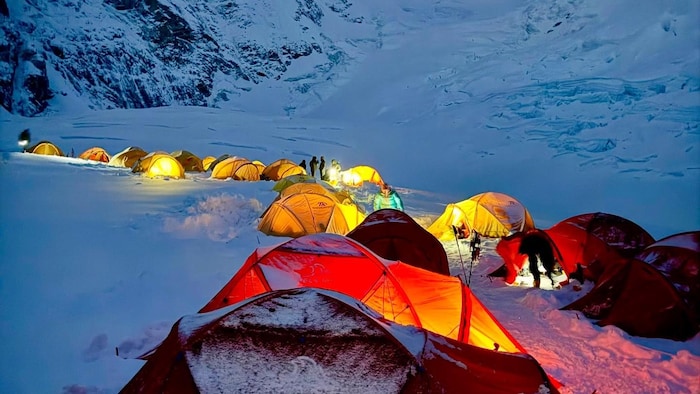 Un campement à flanc de montagne avec des tentes.
