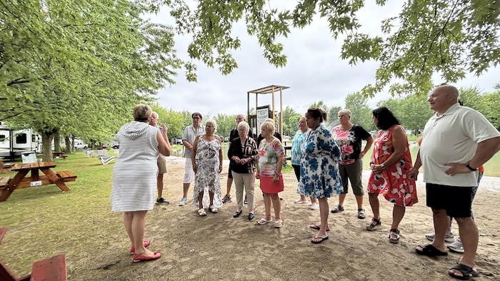 Des campeurs de Sainte-Cécile-de-Milton sont debout dehors au camping.