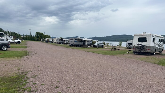 Un terrain de camping sur le bord de l'eau, des véhicules récréatifs stationnés.