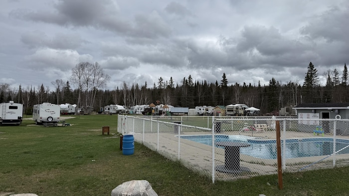 Vue sur une piscine dans un camping plein de véhicules récréatifs.