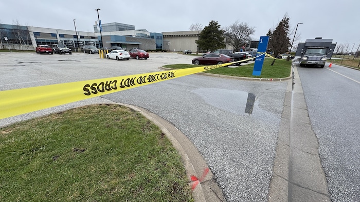 L'accès au stationnement sur le campus du College Lambton est fermé par un cordon jaune qui indique que la police est sur place.