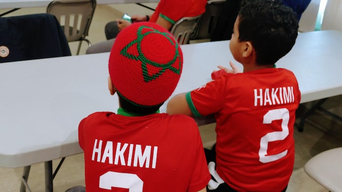 Deux enfants photographiés de dos portant un maillot avec le nom Hakimi.