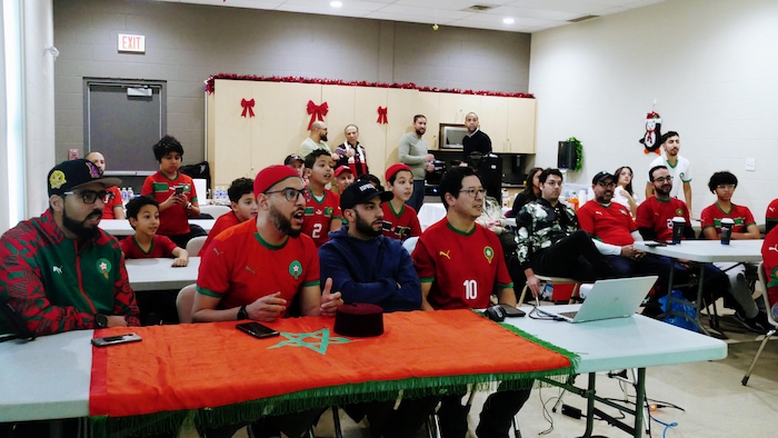 Des partisans regardent un match de soccer de manière attentive.