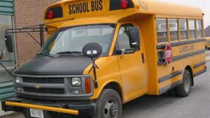 حافلة مدرسية صفراء مزودة بذراع تمديد في مقدمتها. 