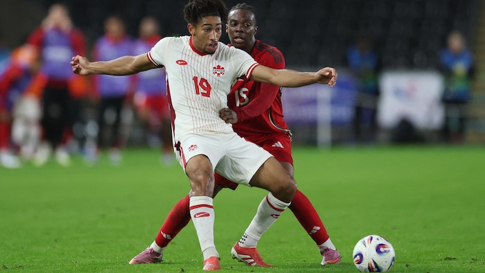 Le joueur du Canada Nathan Saliba devant le joueur du pays de Galles Ronan Kpakio.