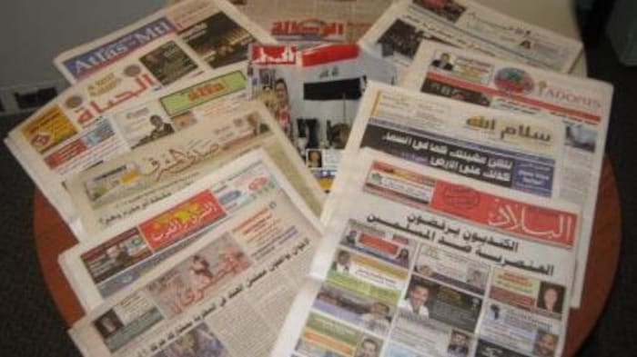 صحف كندية باللغة العربية مصفوفة على طاولة.