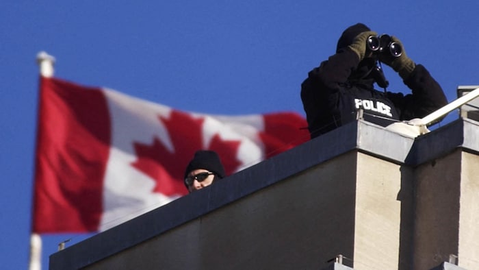 Deux agents de la Gendarmerie royale du Canada monte la garde depuis le toit d’un immeuble.