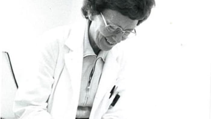 الدكتورة فيرا بيترز تبتسم وهي تعالج مريضةً لا تظهر في الصورة.