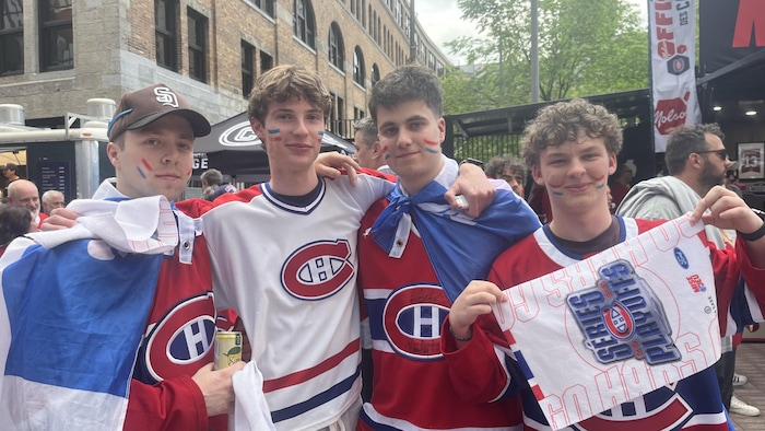 Quatre jeunes partisans du Canadien photographiés devant le Centre Bell.