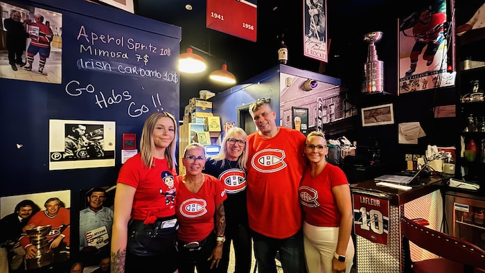 Des personnes portant des chandails du Canadien posent.
