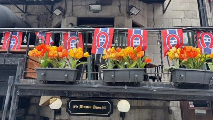 Des drapeaux du Canadiens affichés devant un bar.