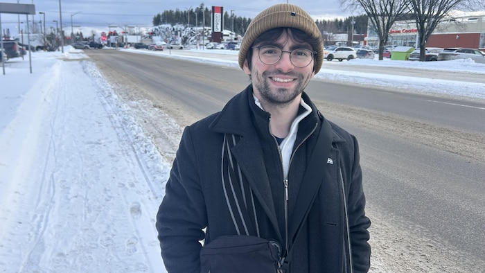 Francis Tremblay pose devant une rue en hiver.