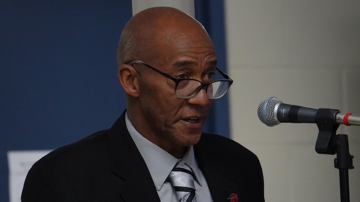 Une personnalité politique au qui parle devant un micro.