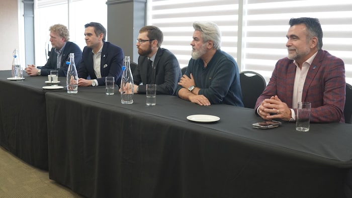 Marc Bélanger, Charles Milliard, Mario Roy, Pablo Rodriguez et Karl Blackburn sont assis à une table.