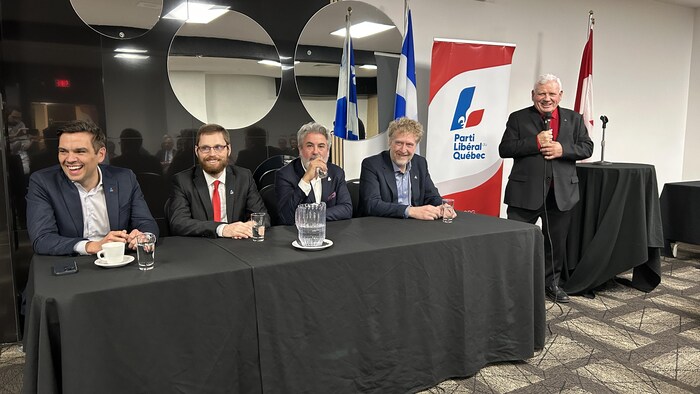 Cinq personnes au micro.