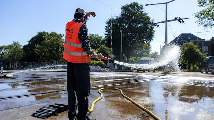 A municipal employee pulverizes water on a deck. millions europeans undergo exceptional early millions europeans undergo exceptional early new