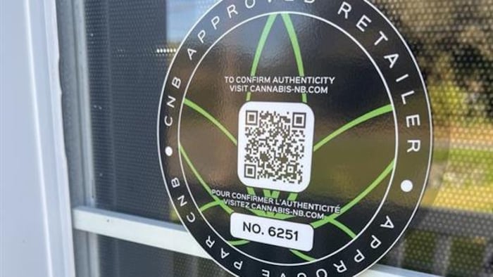 Un badge de Cannabis NB apposé sur une fenêtre. 