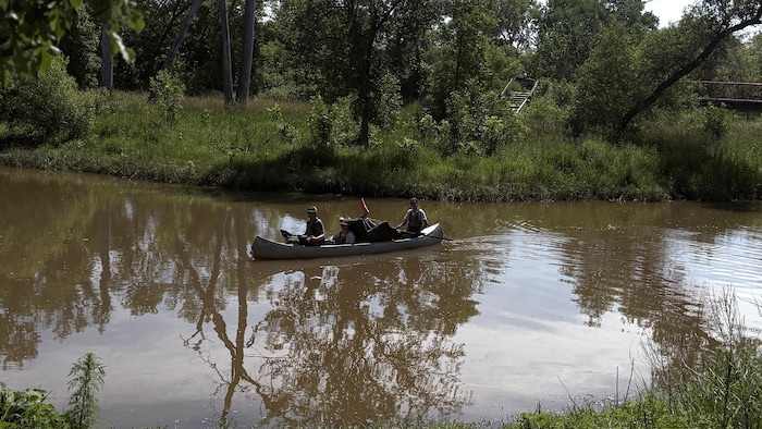 Trois gardiens de la rivière Seine naviguent sur un canot après le ramassage des ordures.