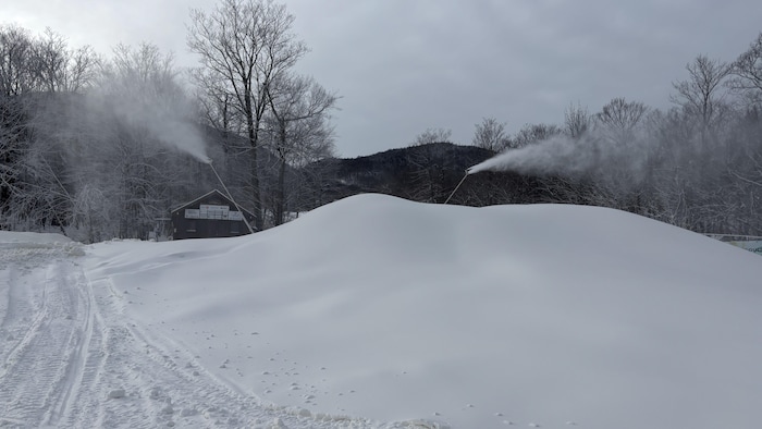 La neige produite par les canons s'accumule avant d'être épandue par les dameuses.