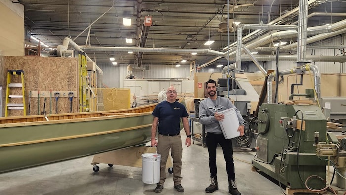 Bruno Forest à côté de Alain Gallant directeur de Canots Rhéaume dans un entrepôt pour la fabrication de canots.