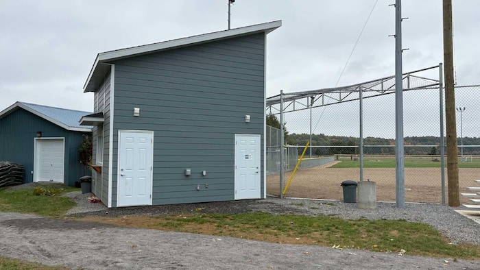 Une cabane près d'un terrain de baseball.