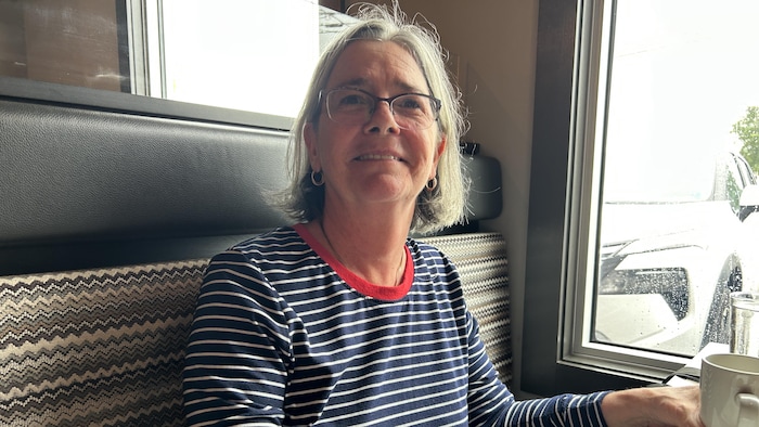 Une femme assise à une table de restaurant.