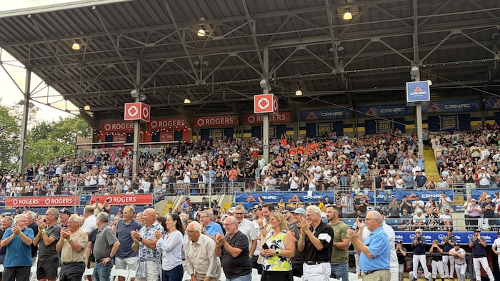 Une foule debout qui applaudit.